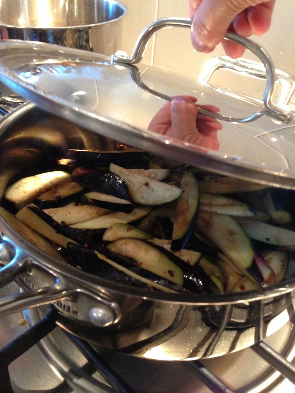 Put on a lid to steam the eggplant. Stir them to evenly coat them in oil.