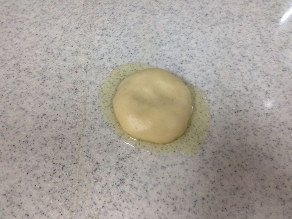 Put on the table some of the oil and a ball of dough