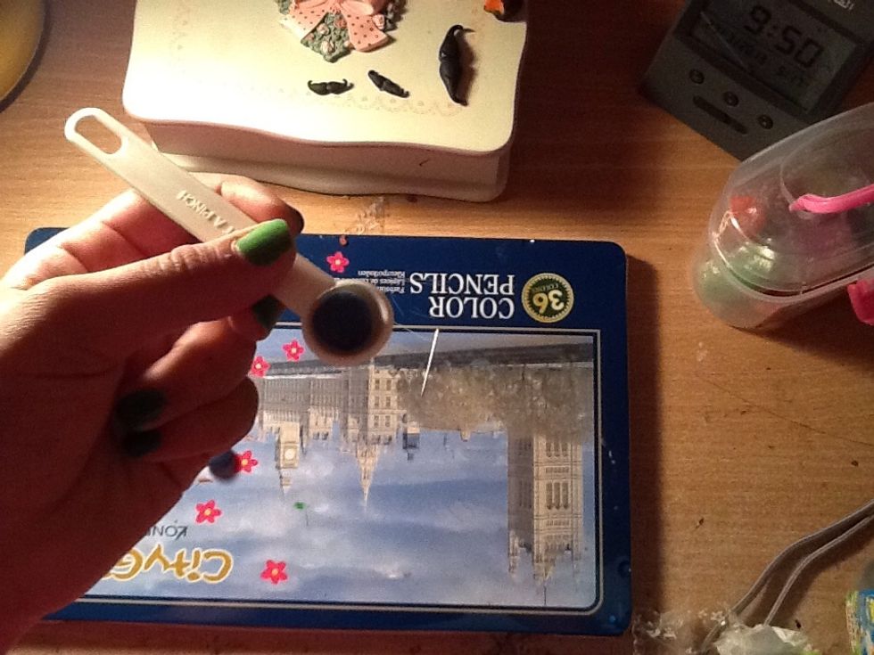 Put one half of the blue clay in the measuring spoon