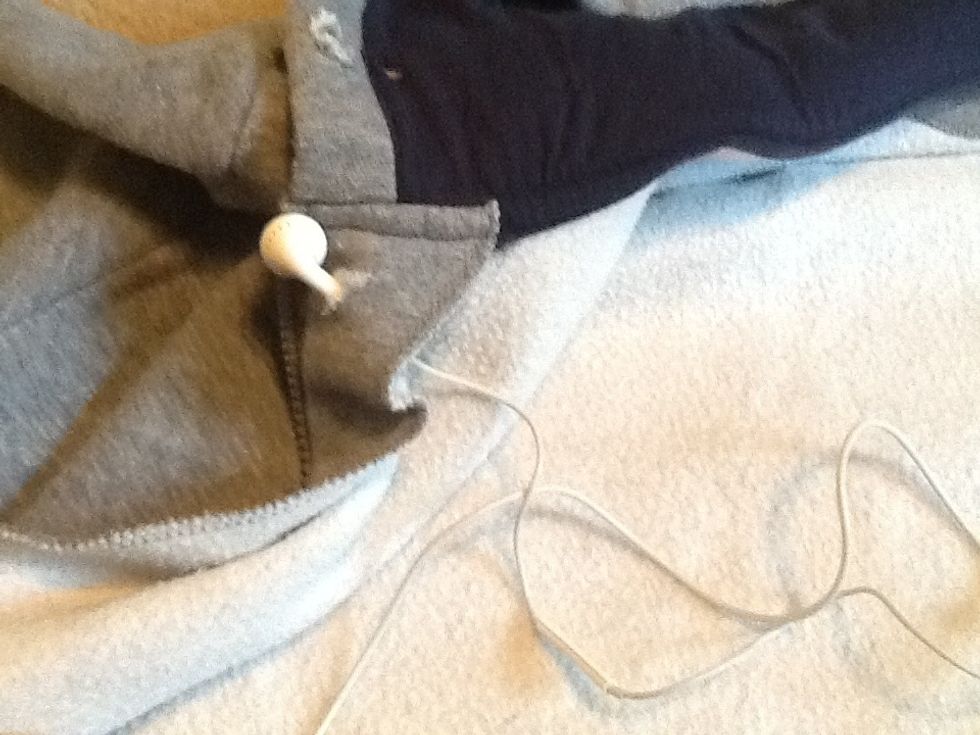 Put one headphone into the hole so that it pops out into the outer shell of the jacket, be sure to use the right headphone for the right side and the left headphone for the left side