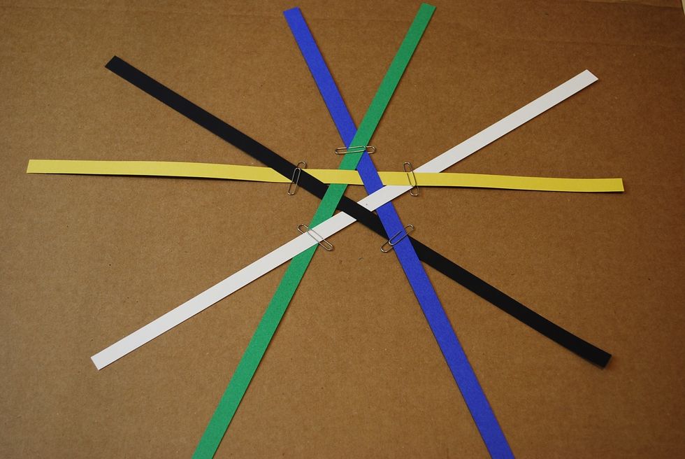 Put paper clips at the point of each star. Sliding your pattern to the edge of the table can help make attaching the paper clip easier.