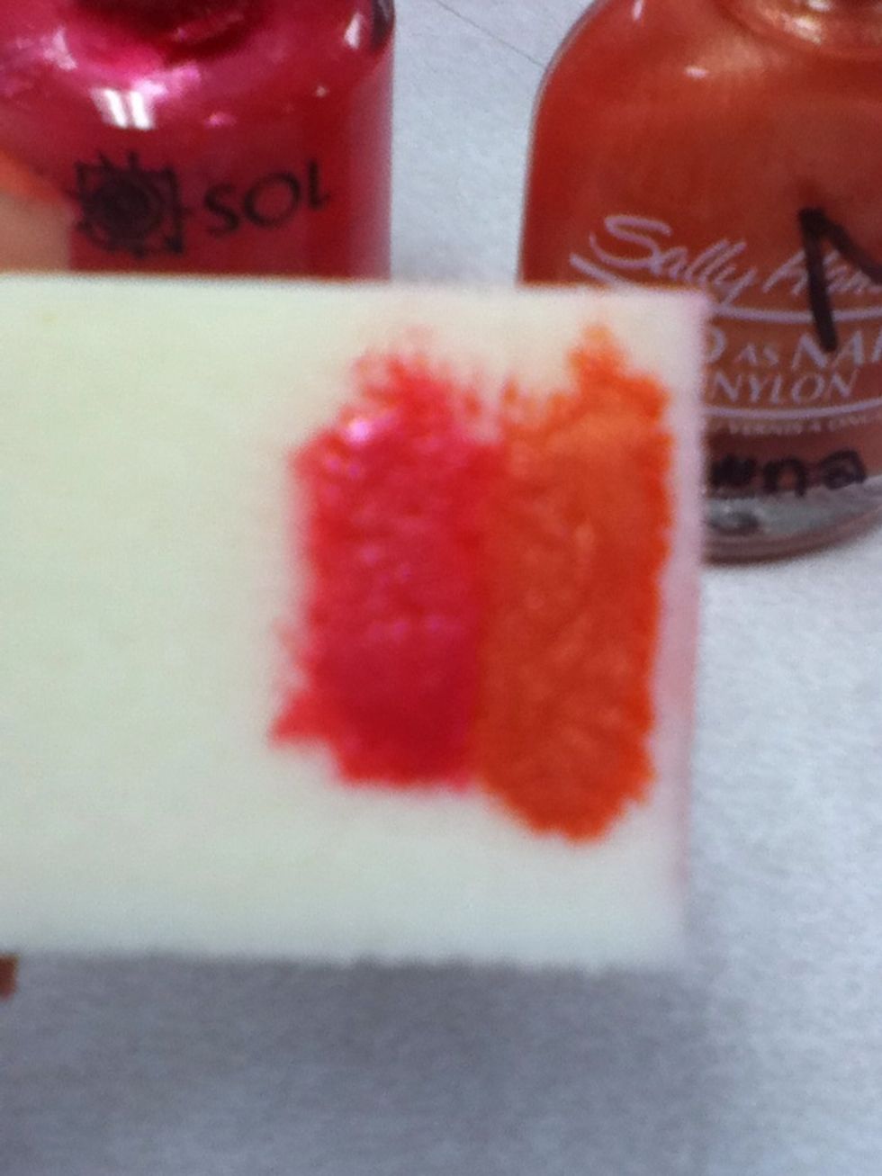 put pink and orange nail polishes on a sponge. do not make a space between them.