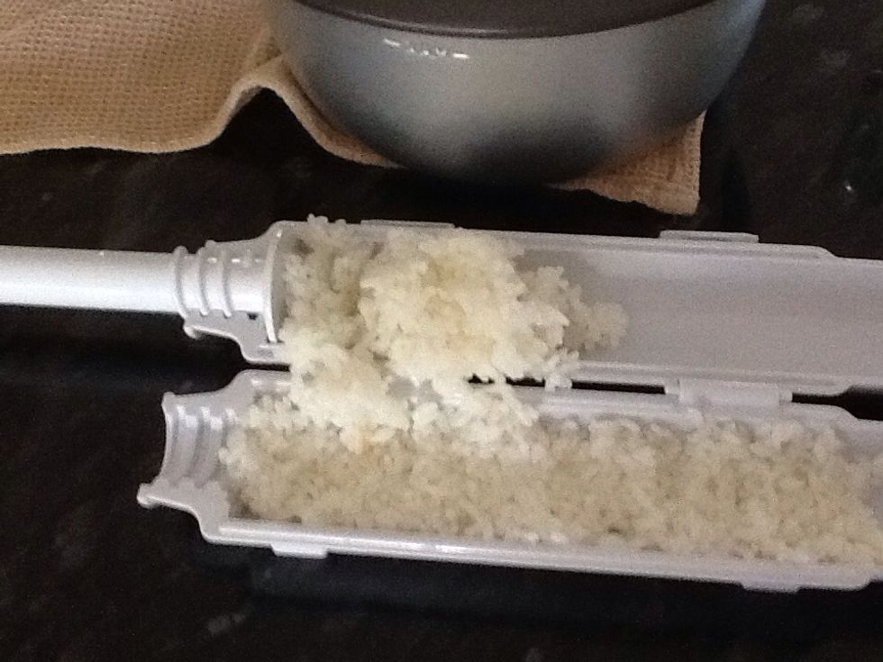Put rice in the sushi maker and spread it out