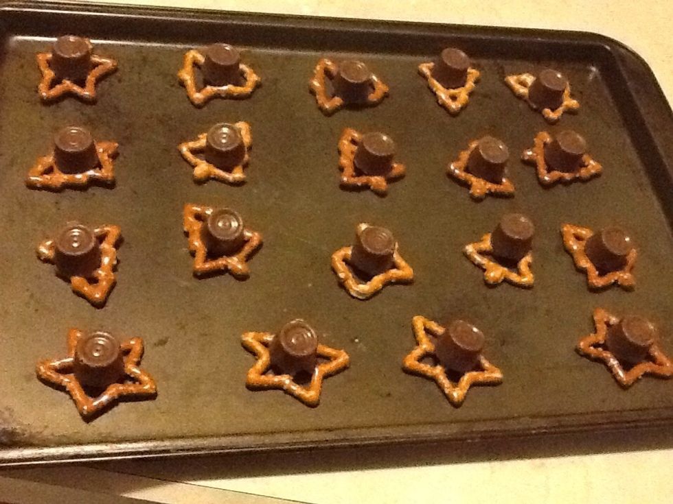 Put rolos on the pretzels.