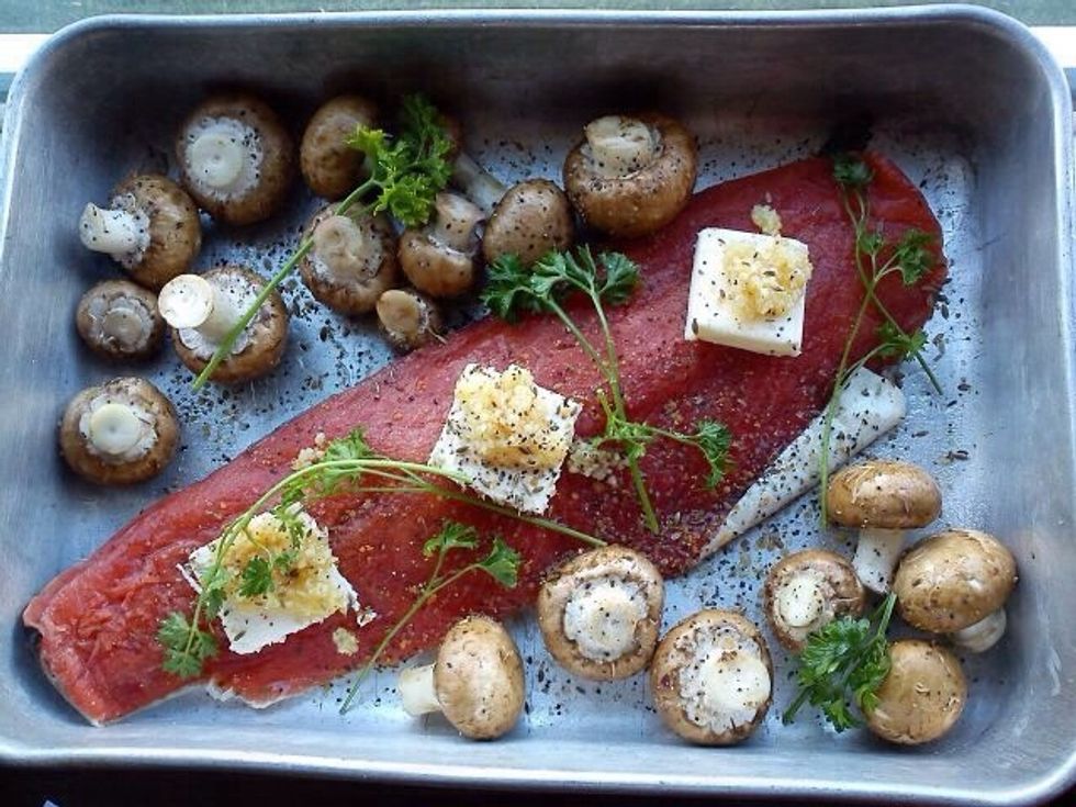 Put salmon fillet and baby portabella mushrooms in baking pan and top fillet with a few pats of butter, some diced garlic, dried dill seed or fresh dill.