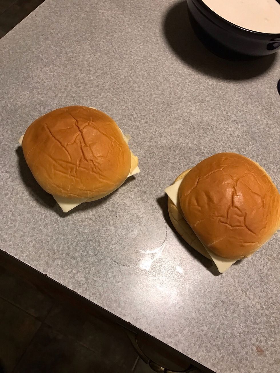 Put Slice of cheese on each burger and a bun, pat it together tightly so it doesn't come apart.
