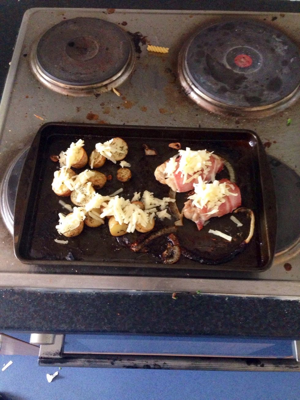 Put some cheese on potatoes and chicken rolls and place back in the oven for 5 minutes.