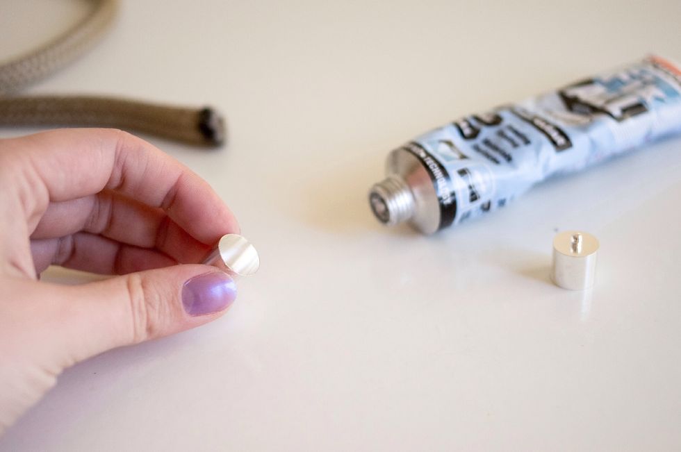 Put some glue to a cap, and glue it to the rope.