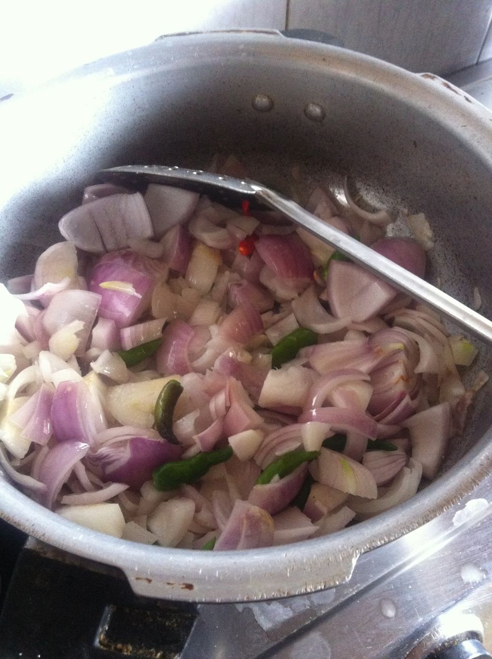 Put some oil in a pan and the chopped onions , let me quickly throw in some green chillies