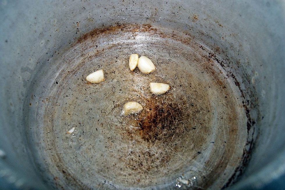Put some oil in a pot over high heat and fry garlic until the garlic is burnt all over. As a guide, leave it until you think you're burning it too much, then leave it for 2 or 3 mins more.