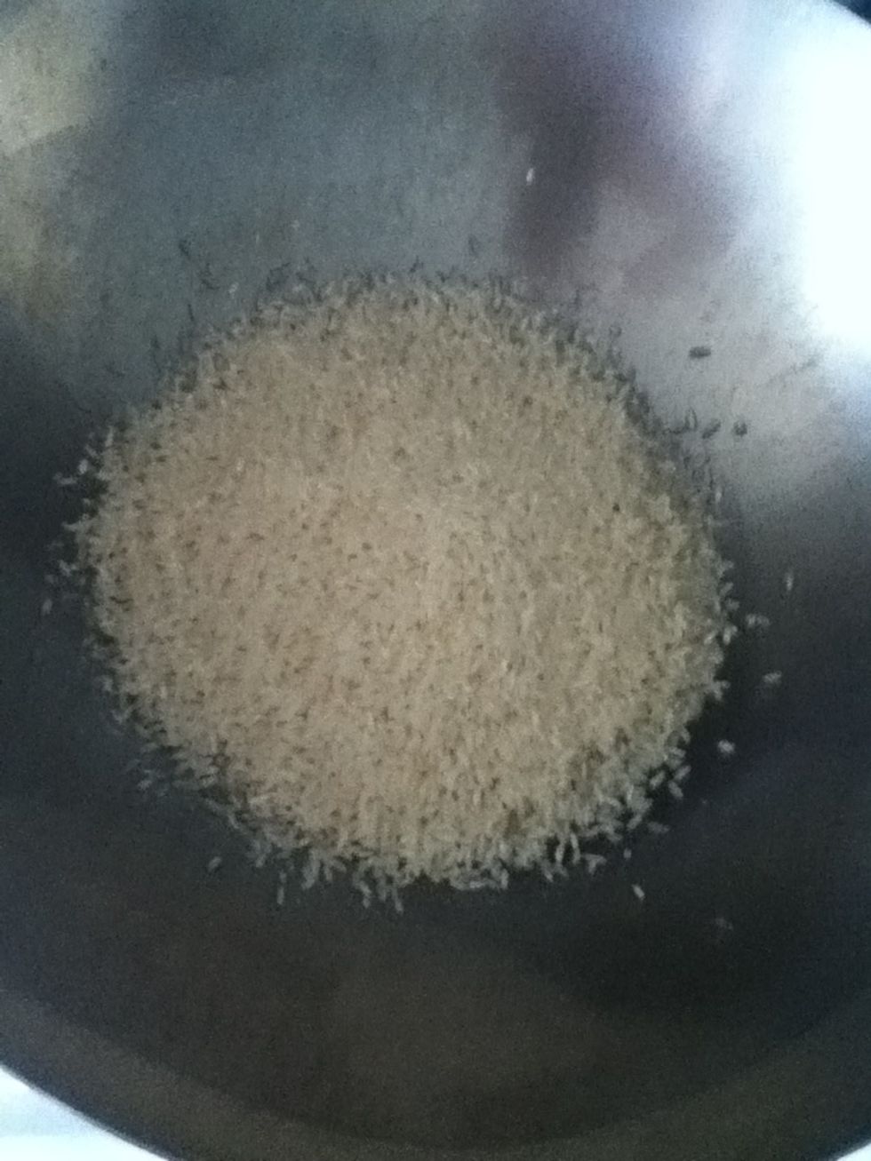 Put some peanut oil in your wok over medium high and add a cup and a half of medium or long grain white rice. Goya is a good brand for this. Stir fry it while it changes color.