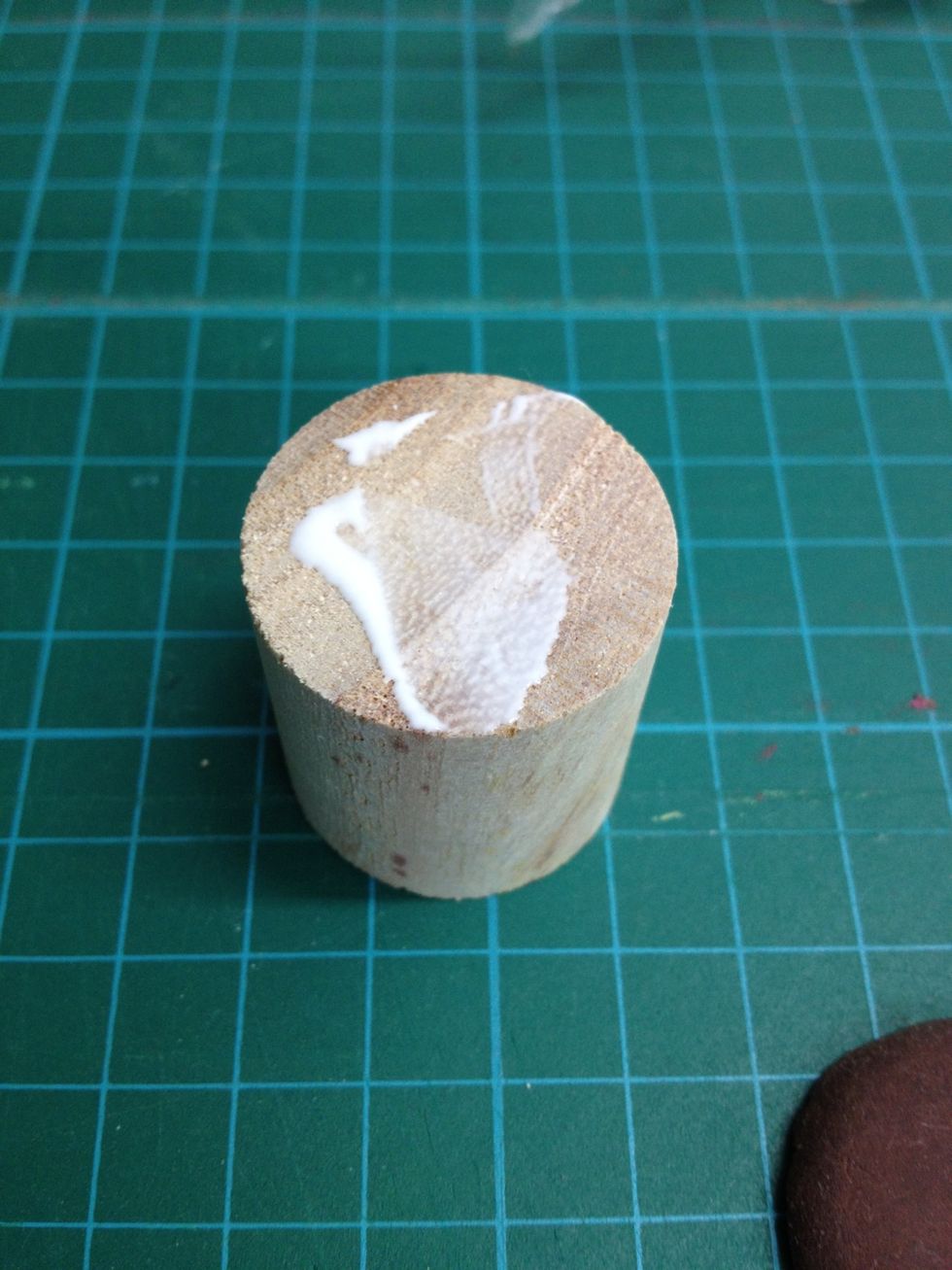 Put some white glue on the wood piece top.