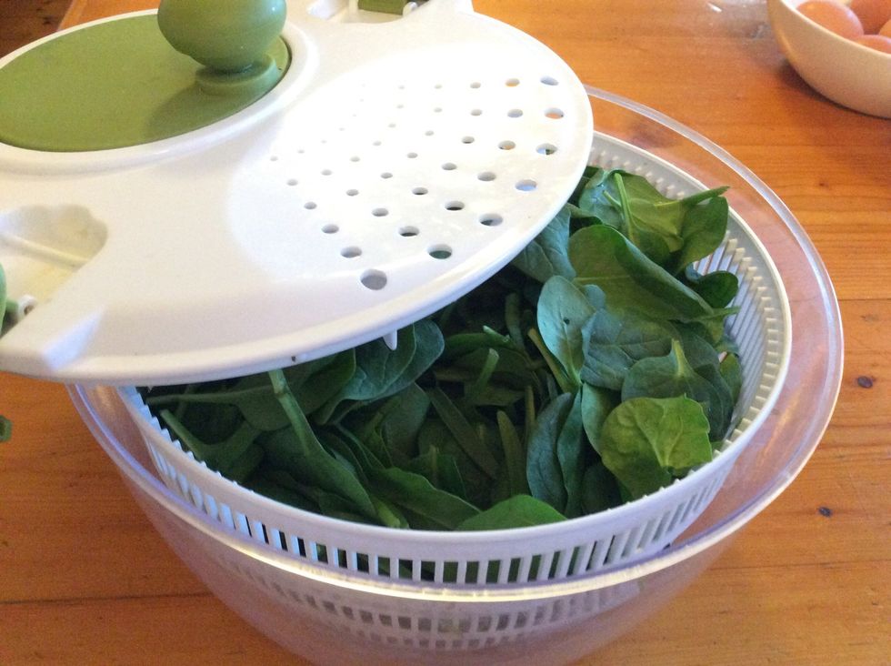 Put spinach leaves into a salad spinner, colander or sieve.