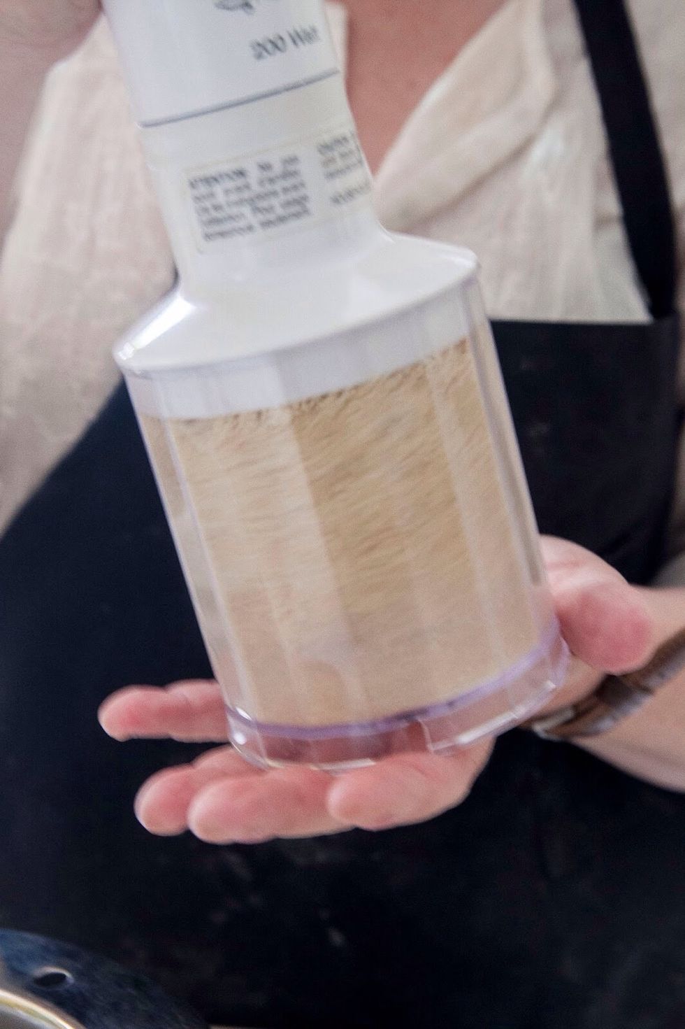 Put the 1/2 cup of peanuts into a grinder and crush them up.