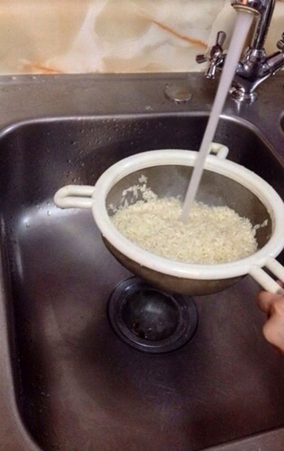 Put the 2 cups of uncooked rice in a large strainer with 2 1/2 cups of warm water.  http://d74bwl3dcueqd.cloudfront.net/images/guide/982d9986465f46d6b4b36d2470e30db 5/315x500_ac.jpg