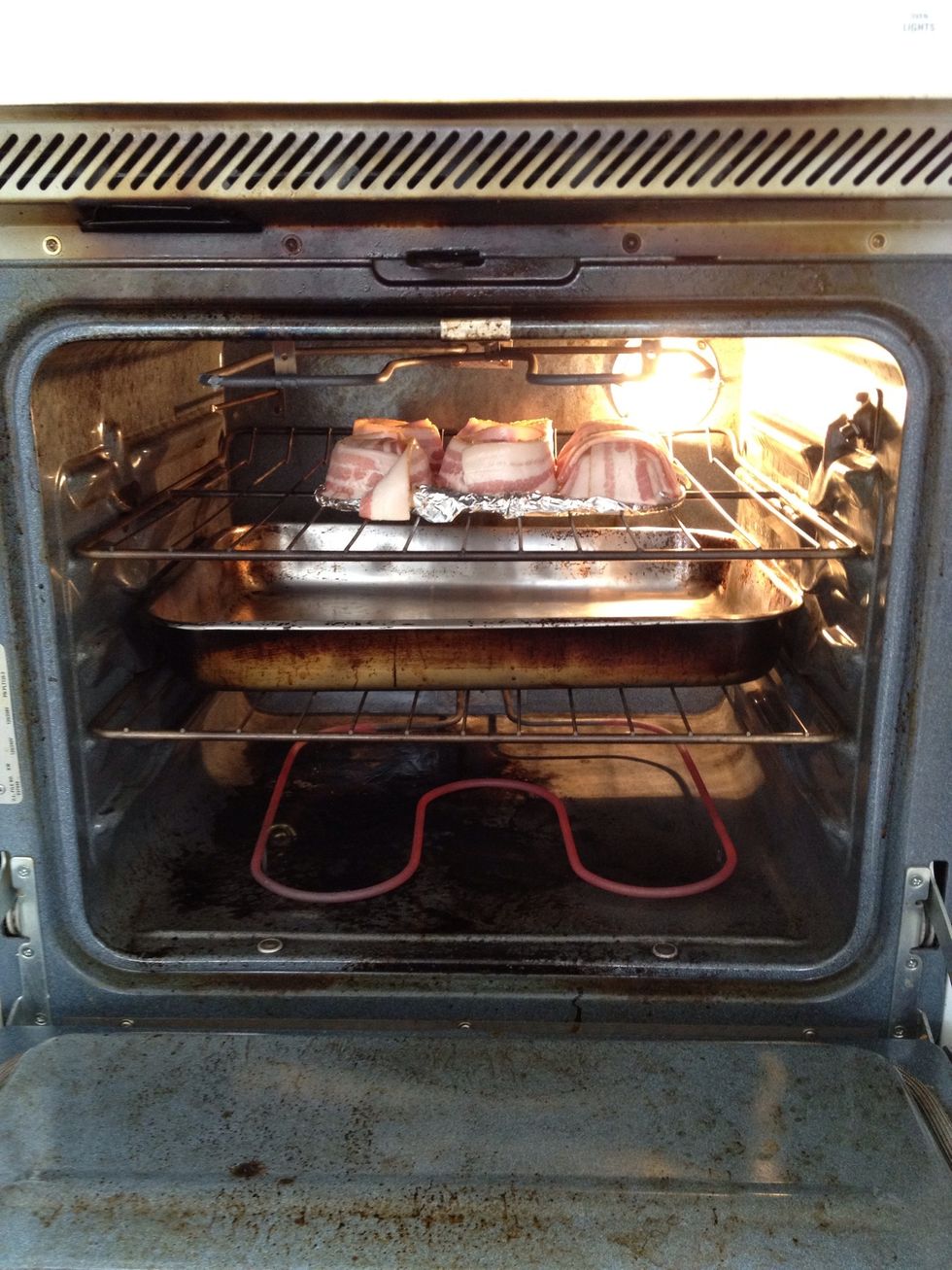 Put the bacon in the oven until crispy. If you can, put a pan under the bacon to catch the fat.