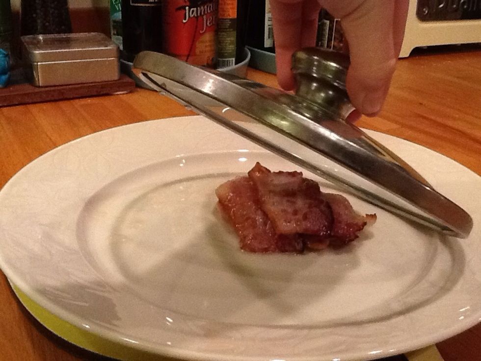 Put the bacon under something that can keep it warm
