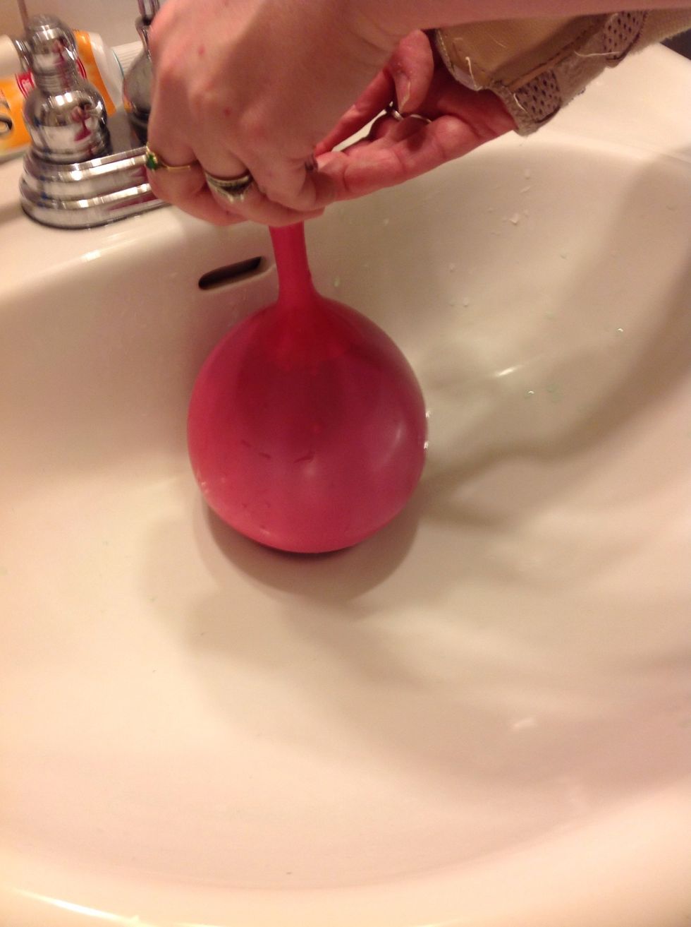 Put the balloon top on the faucet and turn on the water