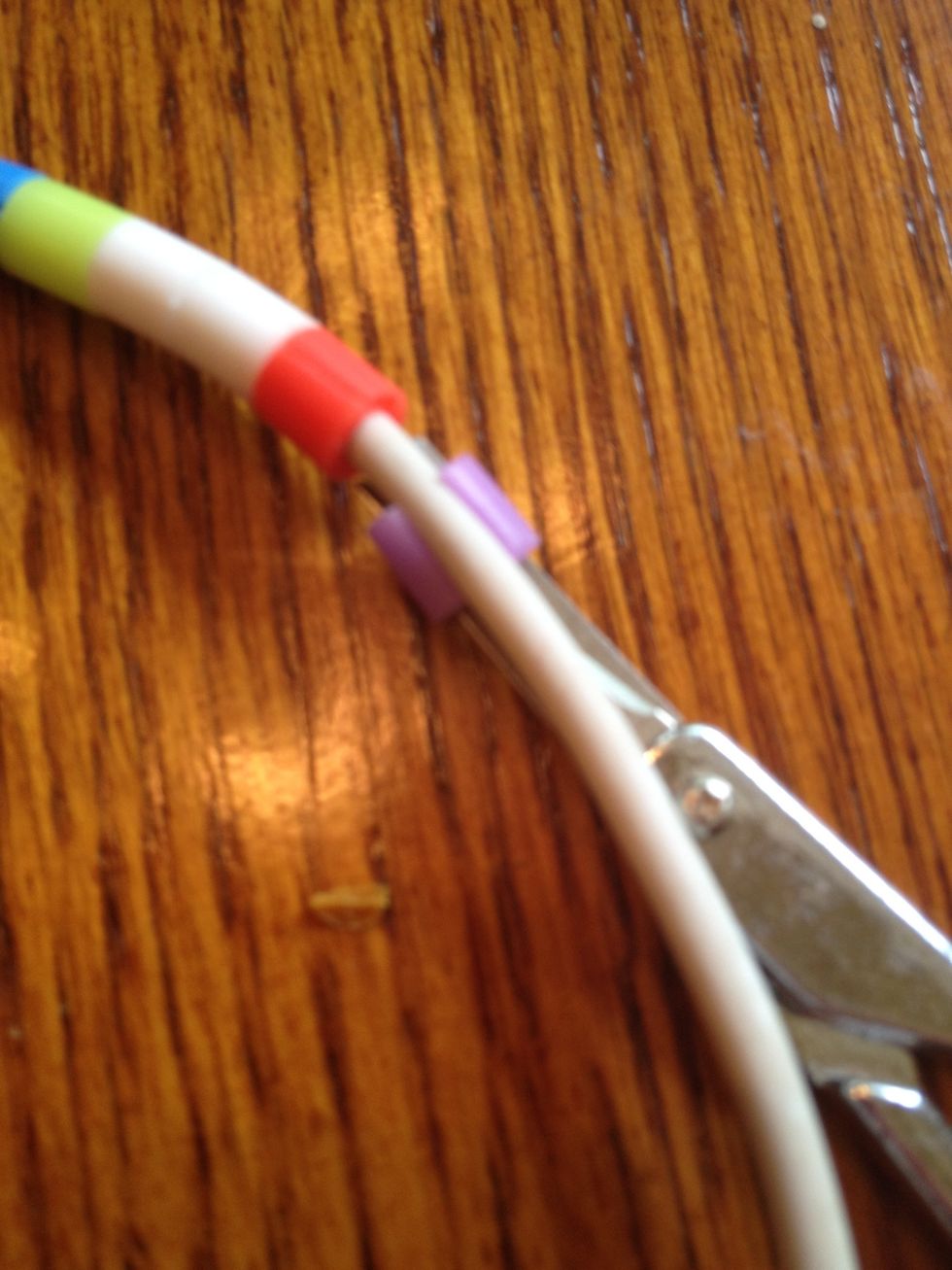 Put the bead around the cord. Careful not to cut the cord.