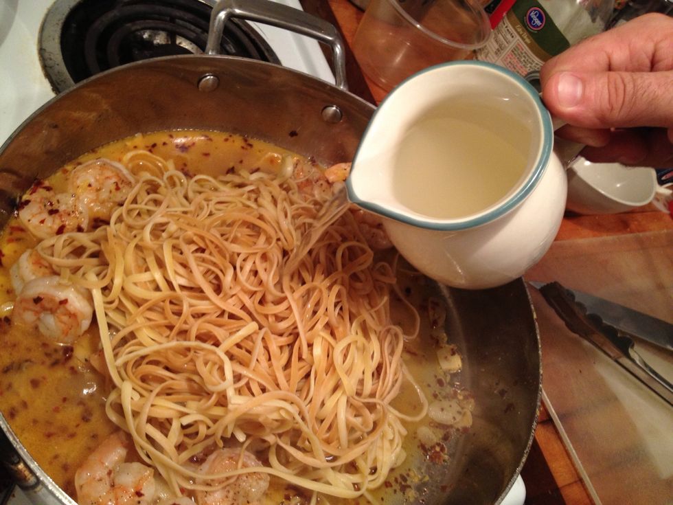 Put the big pile of pasta in the skillet and pour  some of the reserved pasta water to help to separate the pasta and to help thicken the sauce.