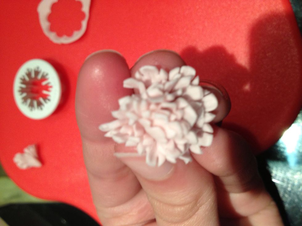 Put the bottom of the flower through the final hole and squeeze