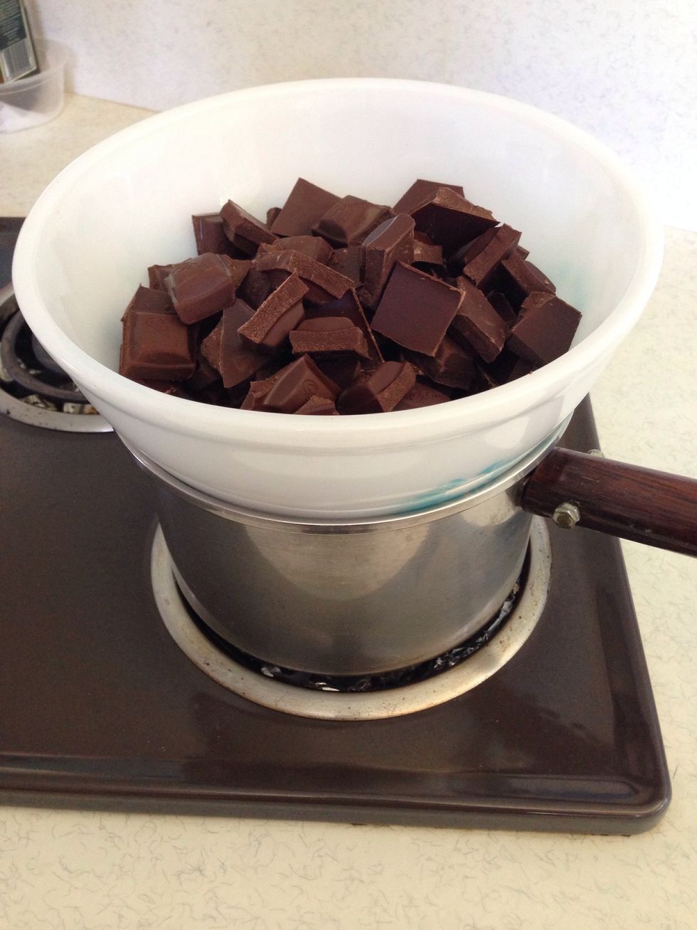 Put the bowl over a pan of very gently simmering water and let the chocolate melt until it's very smooth. Remove the bowl from the water and allow to cool.