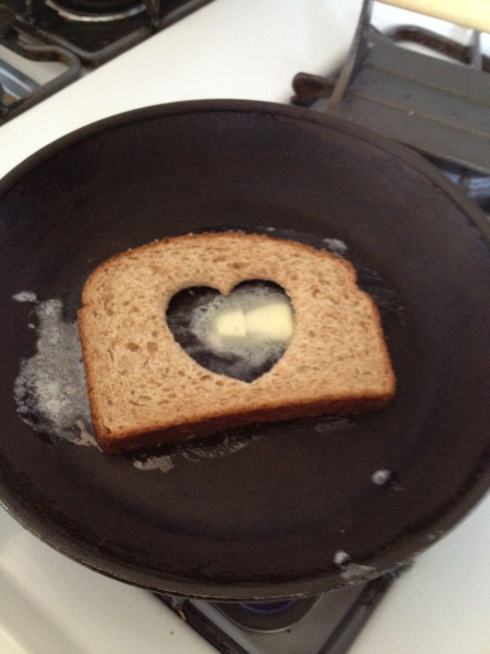 Put the bread in the melted butter and then turn over. Basically you want both sides buttered before you drop in your egg.