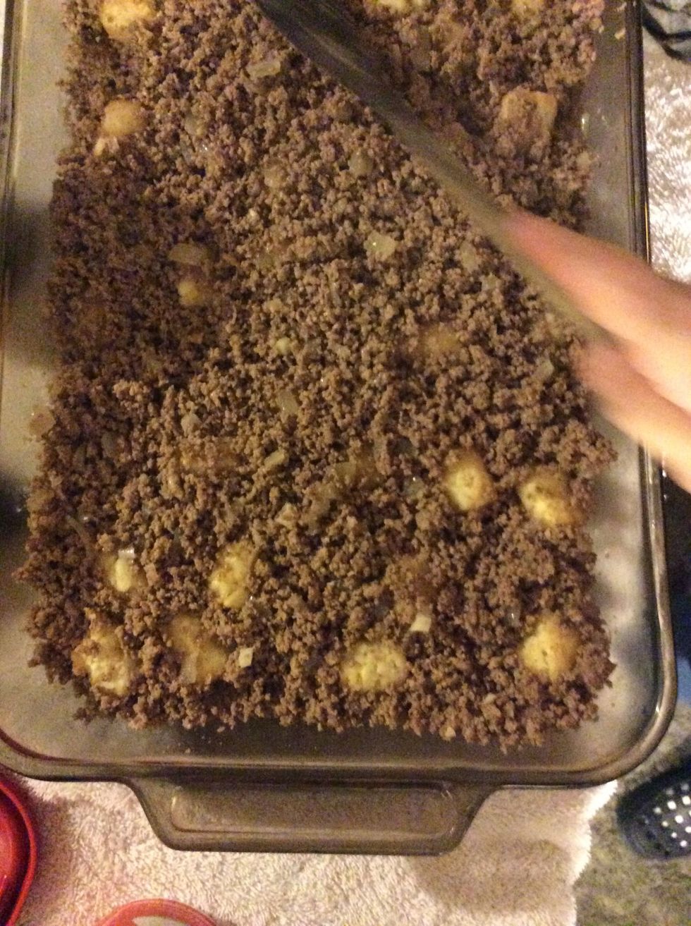 Put the browned meat with garlic,chopped onion over tater tots