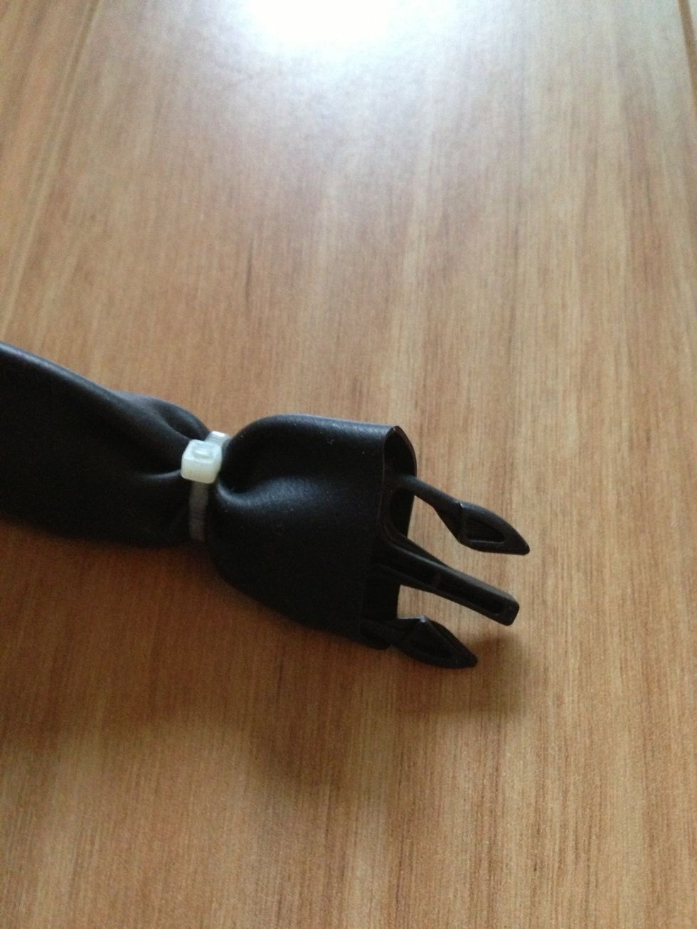 Put the buckle with the nylon inside the tube and leave a spare that you would use to flip and fold back after you tie a cable wire between the knot and the buckle. Do not forget to cut the wire