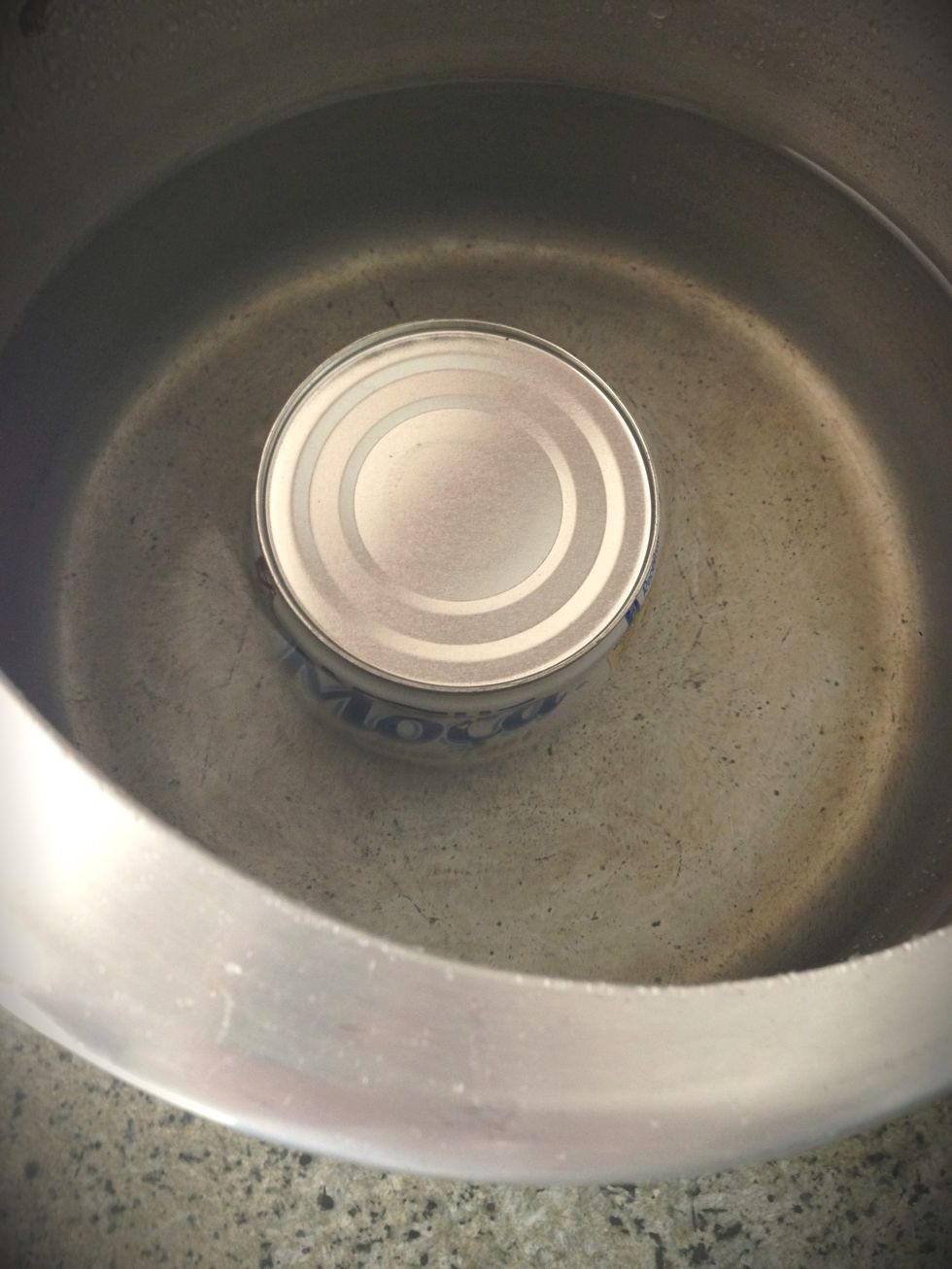 Put the can on a pressure cooker with water on the can level
