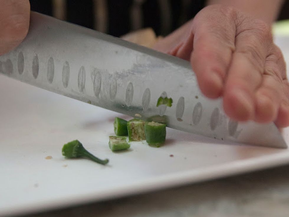 Put the cardamoms and bay leaves and cloves into a small bowl and set aside for later. Chop two serrano chilies finely and put them in the bowl with the cardamoms and cloves.