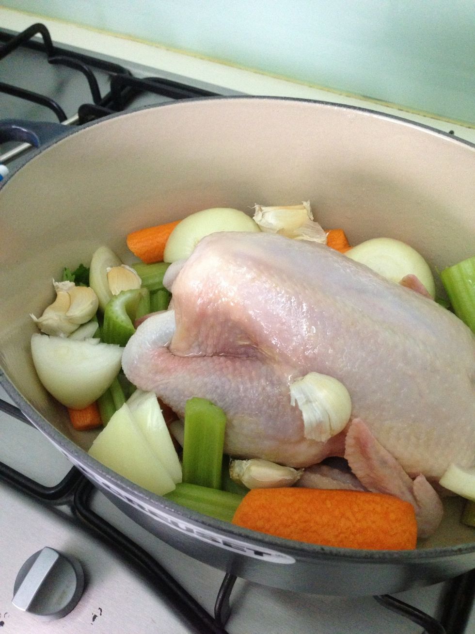 Put the chicken in the casserole. Add in chopped onions, carrots and celery