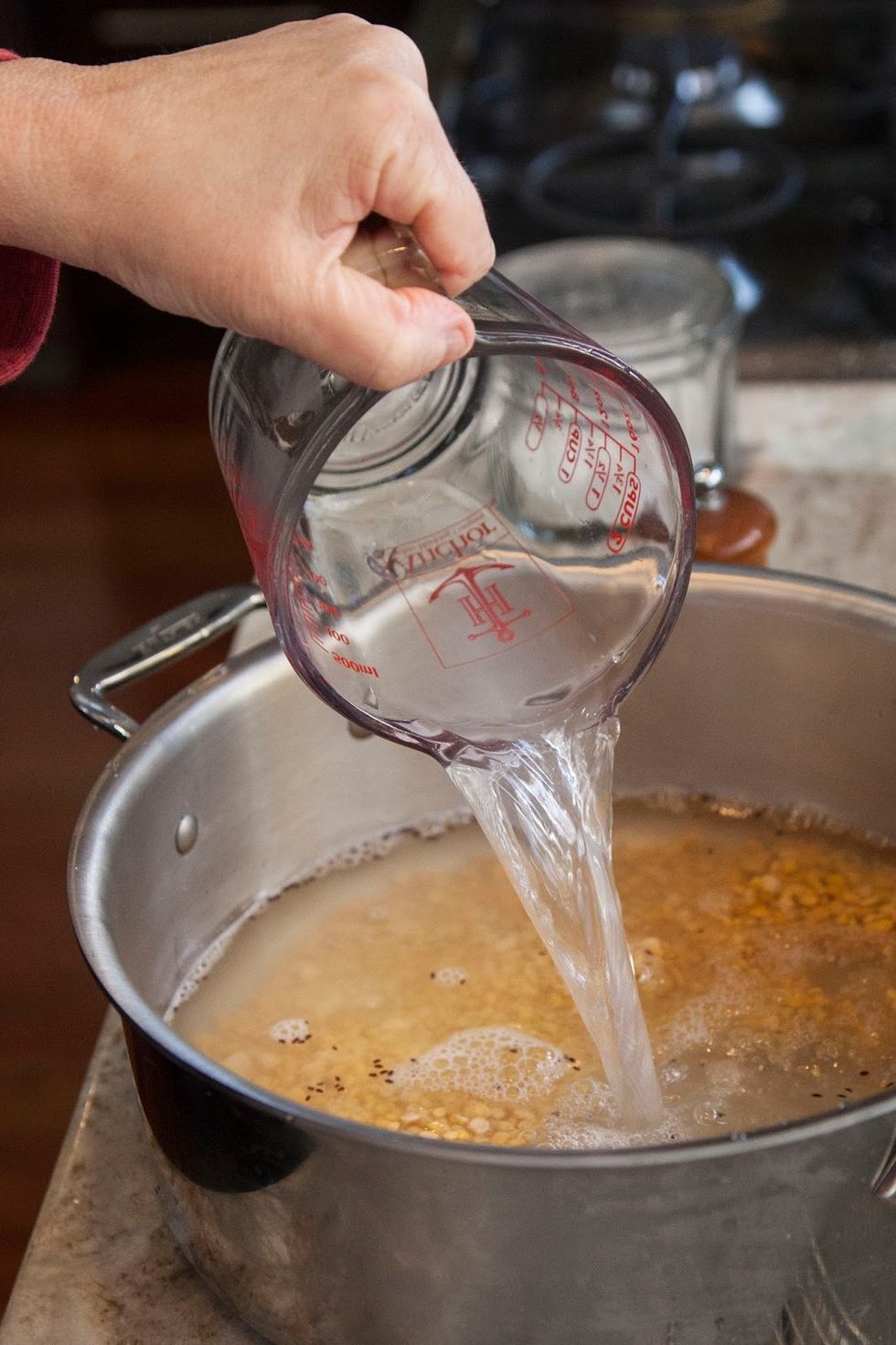 Put the cleaned dal into a pot and add in 5 1/4 cups of hot water.