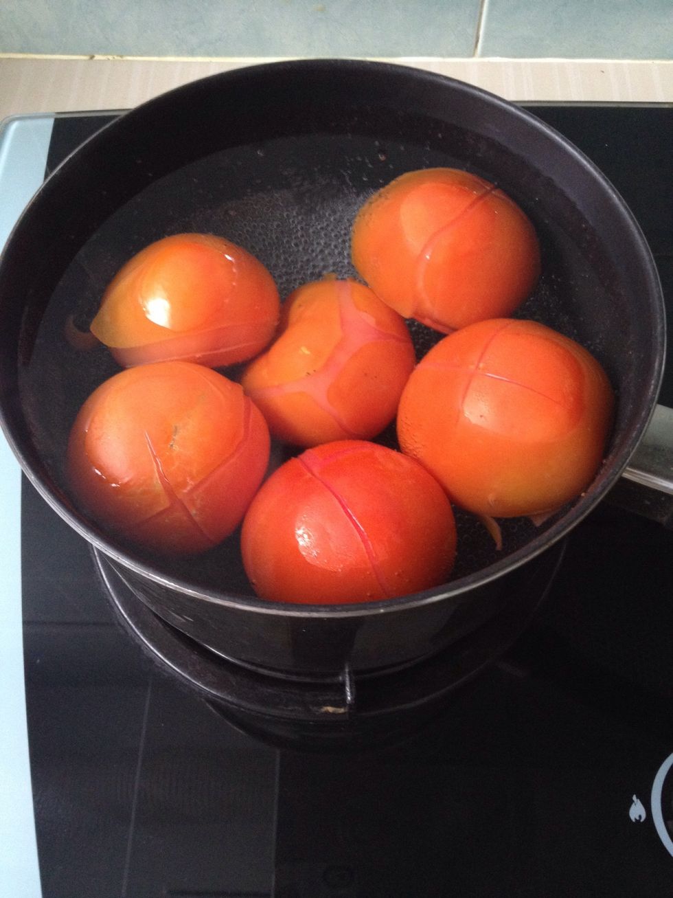 Put the cleaned tomatoes into the pot of boiling water and let it simmer for about 5-8 minutes on medium heat