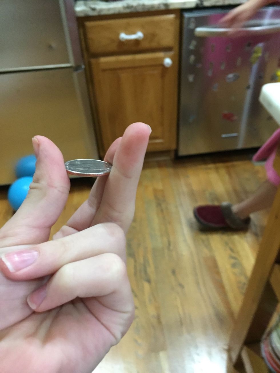 Put the coin between your fingers and above your hand.