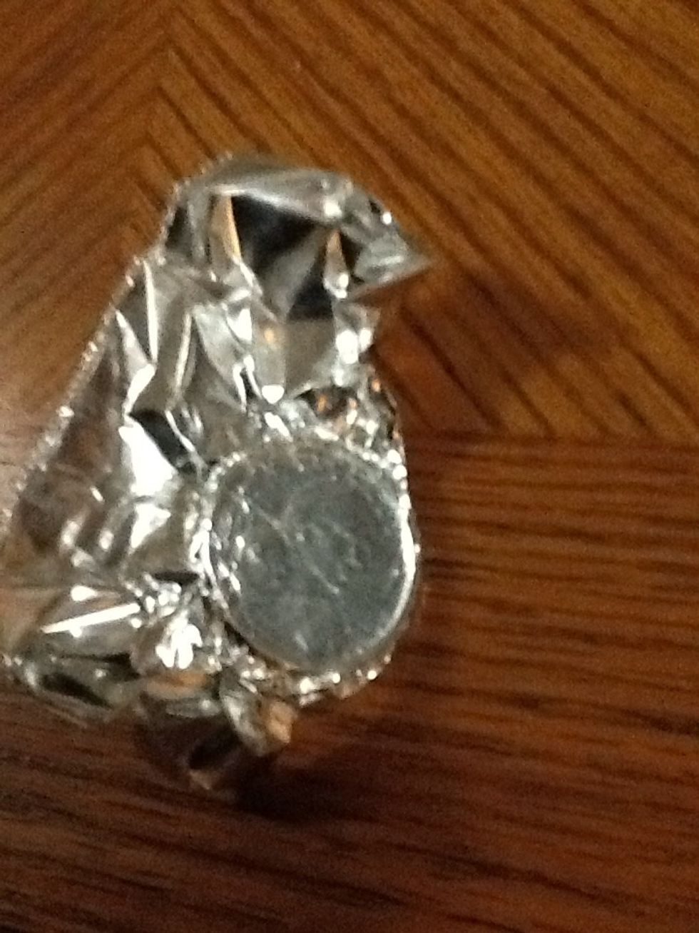 Put the coin in the tin foil and make so you can see the face.