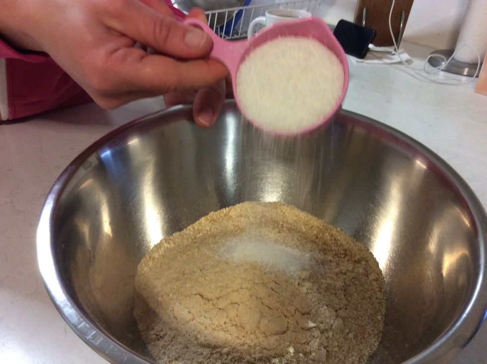 Put the cookie crumbs into a large mixing bowl. Now add half a cup of desiccated coconut into the bowl.
