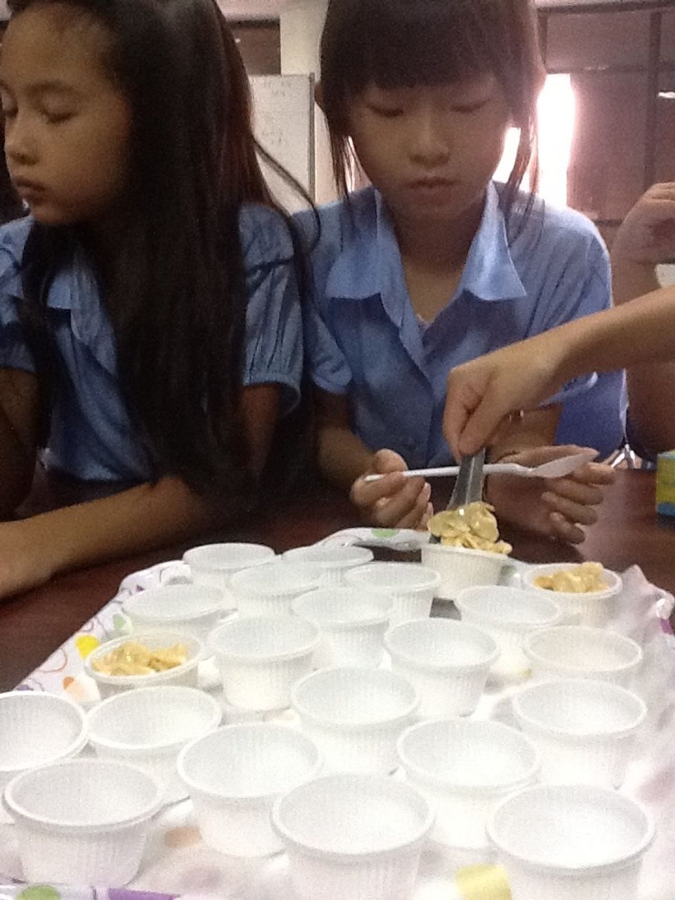 Put the cornflakes into the small cups.