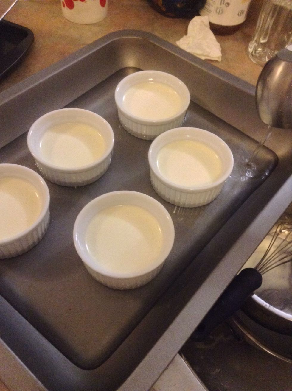 Put the Cr\u00e8me Br\u00fbl\u00e9es onto a baking tray and add water like I did in the picture.