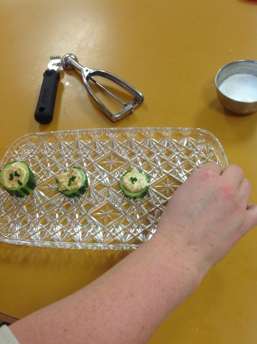 Put the cucumber son a tray and top with the dark green part of the scallion.