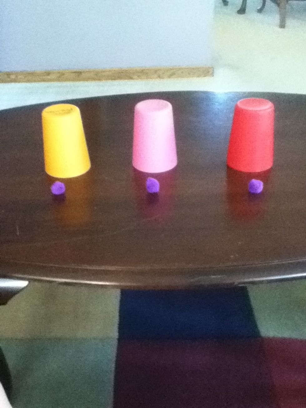 Put the cup over the puff ball.