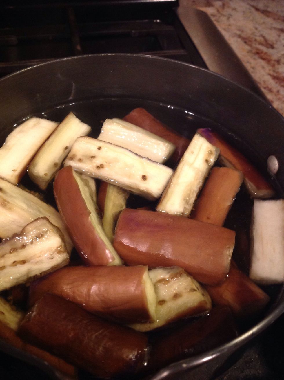 Put the cut eggplant in hot water so it cooks for sometime.