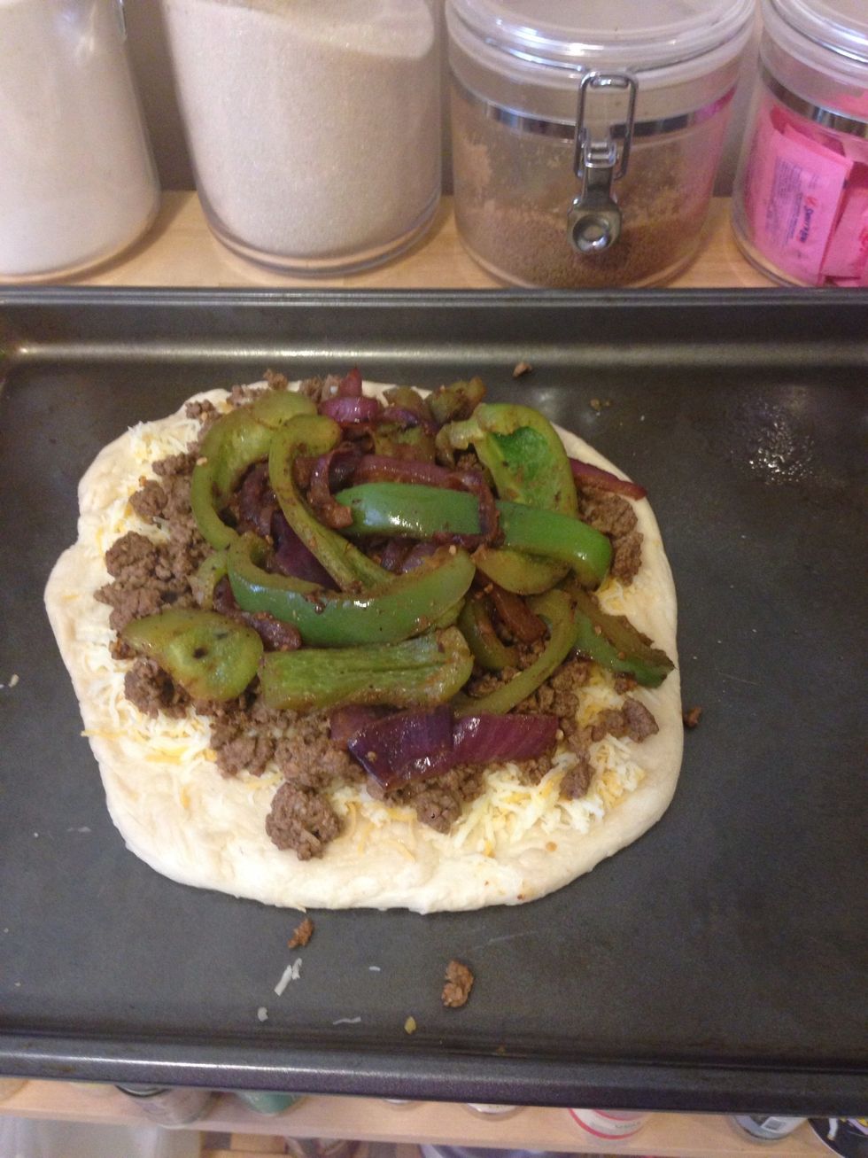 Put the desired toppings on. I sprinkled a bit of olive oil on the crust, 3 oz of Mexican cheese, the beef, and the onion mixture. You could also use marinara or salsa for the base.