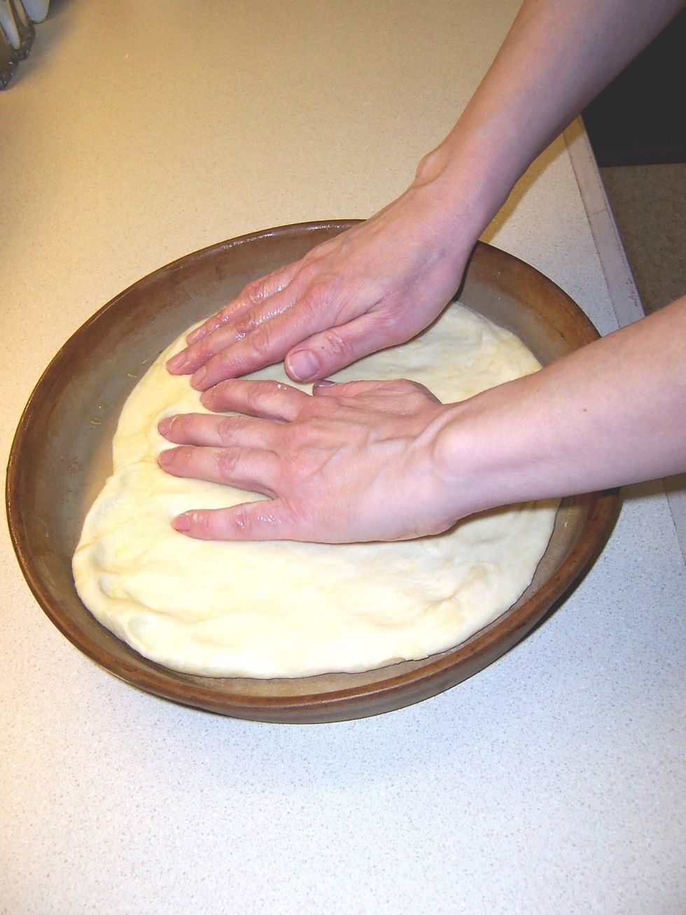 Put the dough in a pizza pan.