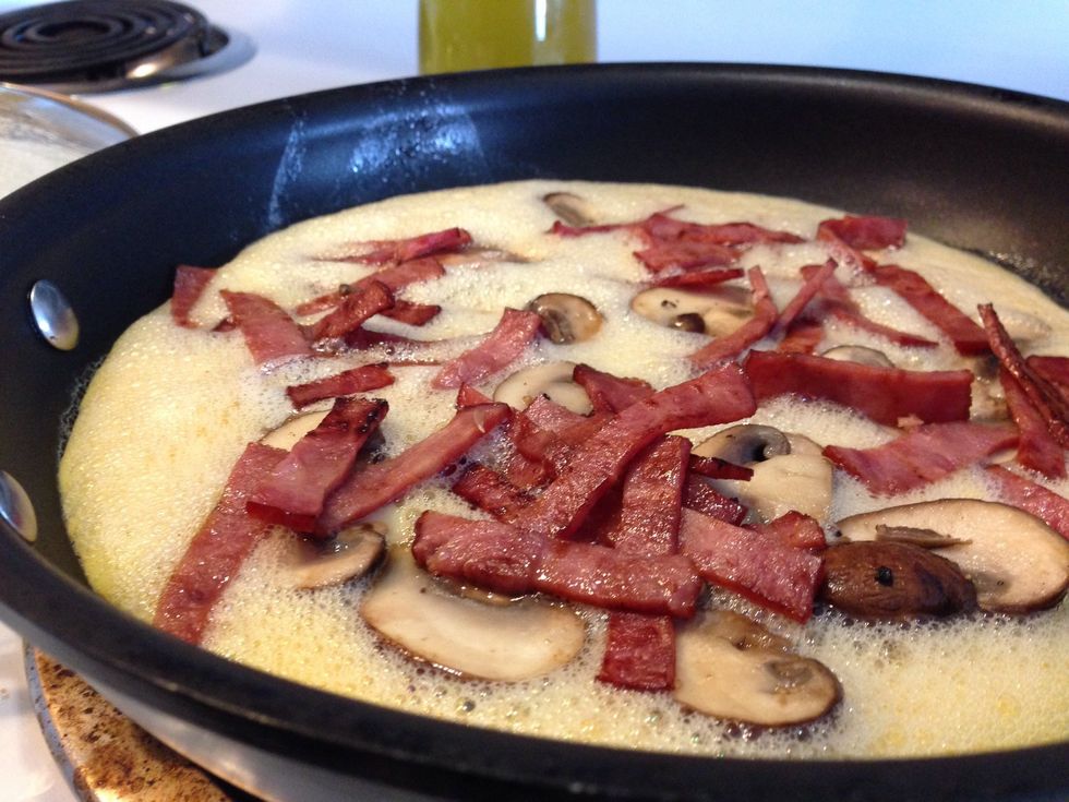 Put the eggs on medium high heat and put the lid on the pan for three minuets. After the three minuets add the mushrooms bacon and cheese. Then put the lid back on.