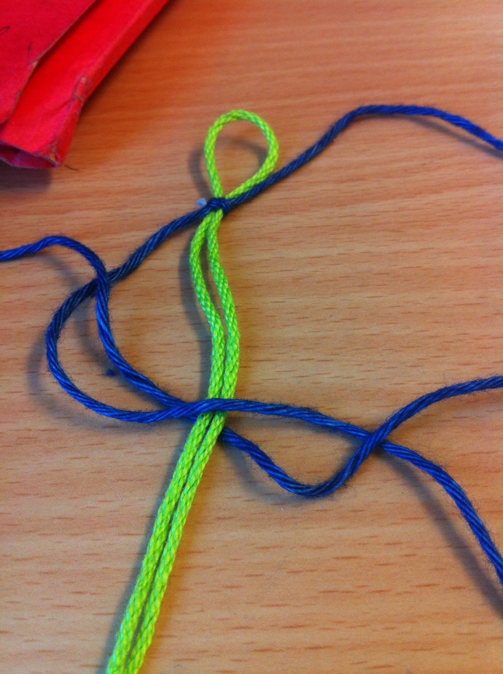 Put the end you just put over the blue one and let it go under the Green and up in the blue ring. (See picture)