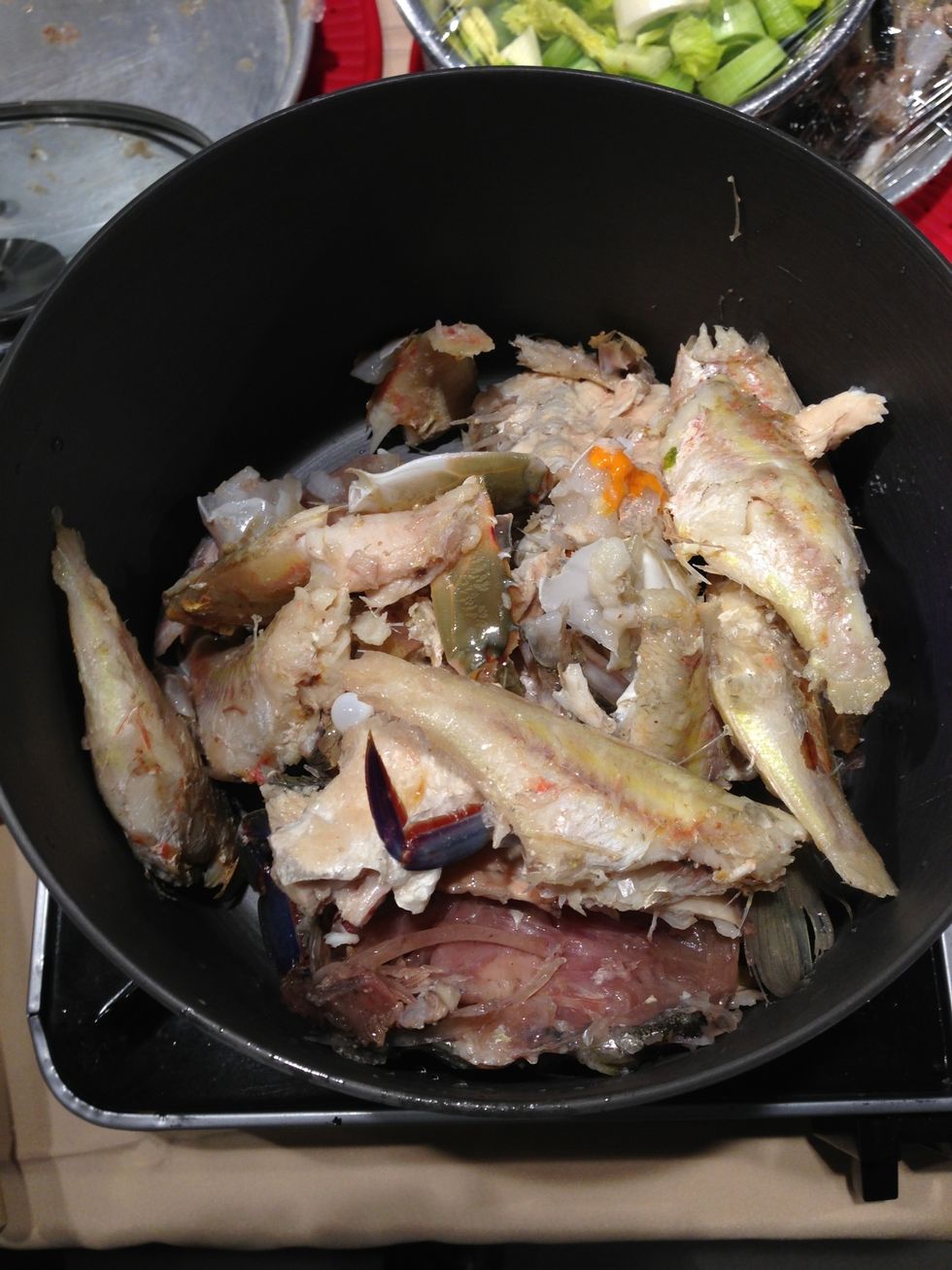 Put the fish bones and crab bits into the pot