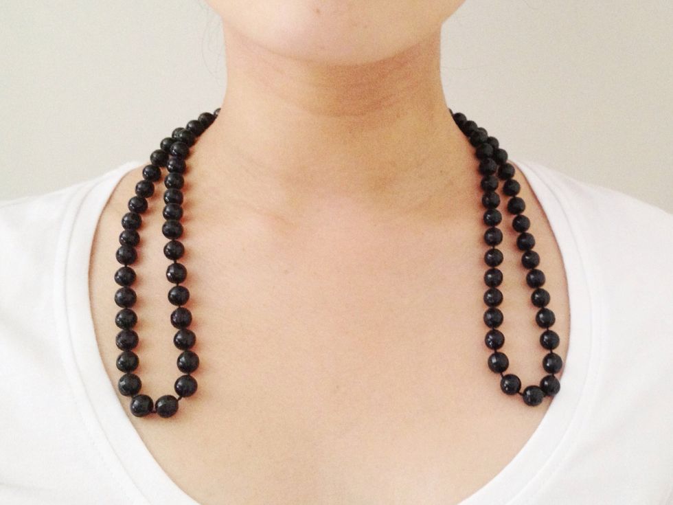 Put the folded necklace behind your neck, so the ends hang down in front.