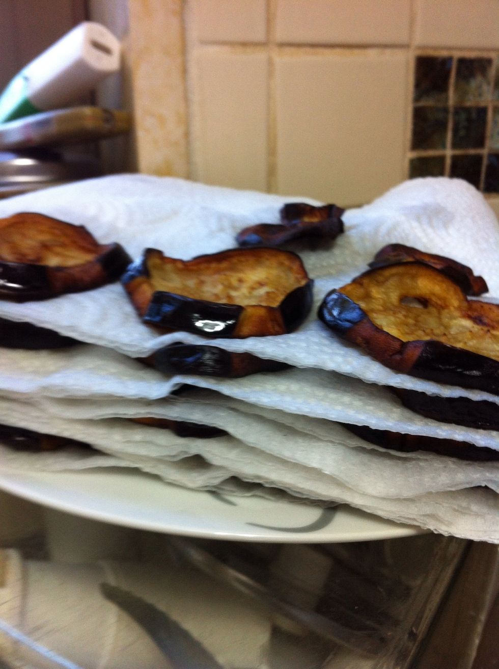 Put the fried eggplants on blotting paper to reduce the oil from the frying