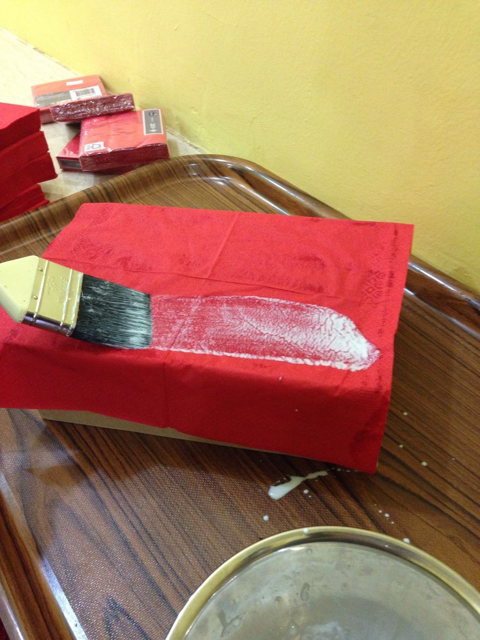 Put the glue on the box ' then we stick the red tissue on the box
